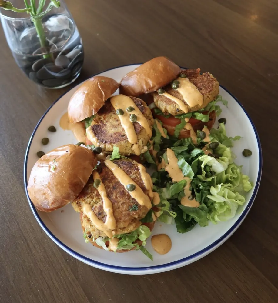 Salmon burgers on brioche with lettuce, tomato, capers and sauce